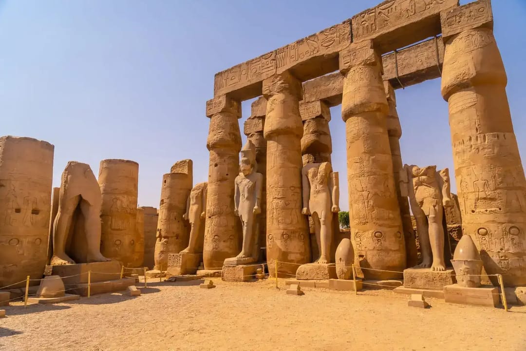 Pharaoh statues and carved columns in the Luxor Temple colonnade