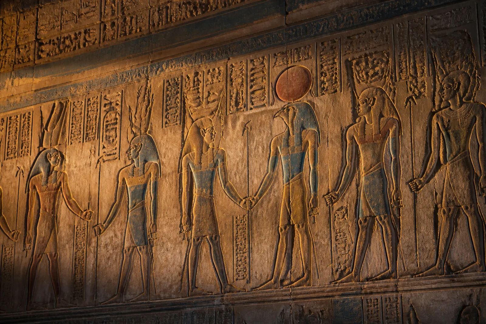 Carved hieroglyphs and painted reliefs at Abydos temple in golden hour