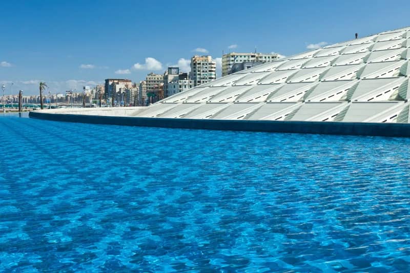 Cubierta de la Biblioteca de Alejandría junto a un estanque azul