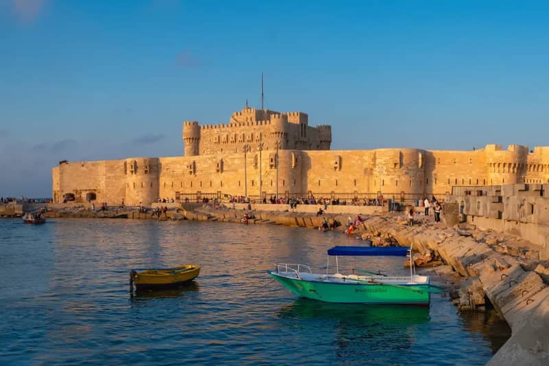 Fort de Qaitbay sur le front de mer méditerranéen, avec de petits bateaux au premier plan