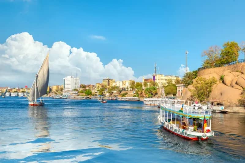 Rive du Nil à Assouan avec une felouque et un bateau touristique
