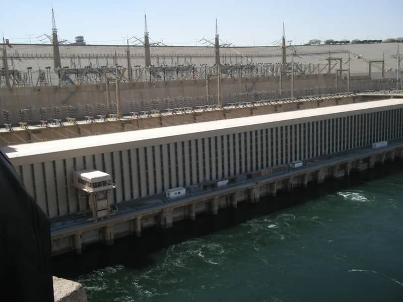 Mur de béton et bâtiments de la centrale du haut barrage d'Assouan au-dessus d'une eau sombre