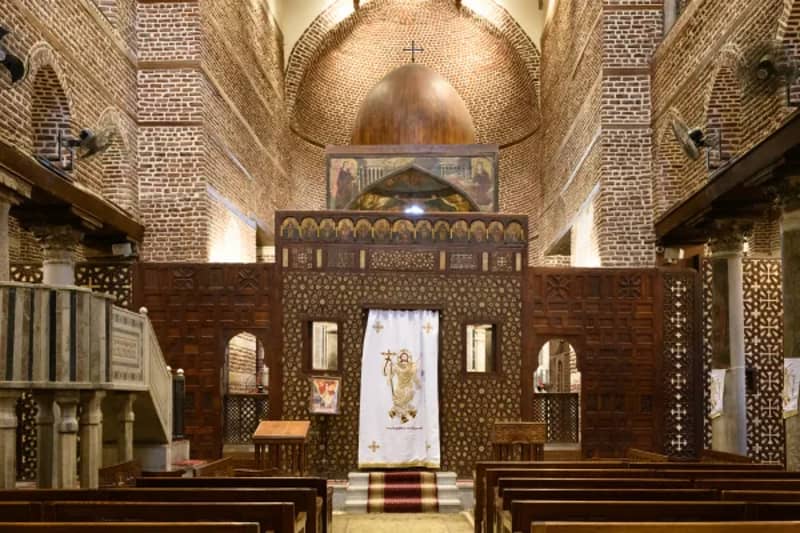 Innenraum einer koptischen Kirche in Kairo mit geschnitzten Holzwänden und Kuppeldecke