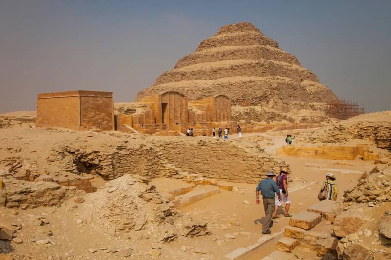 Visiteurs marchant vers la pyramide à degrés de Djéser à Saqqarah