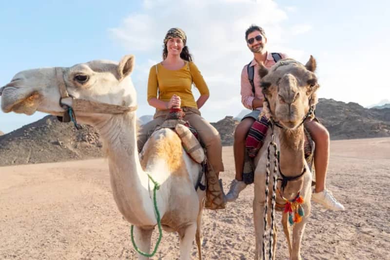 Dos viajeros a lomos de camello en el desierto