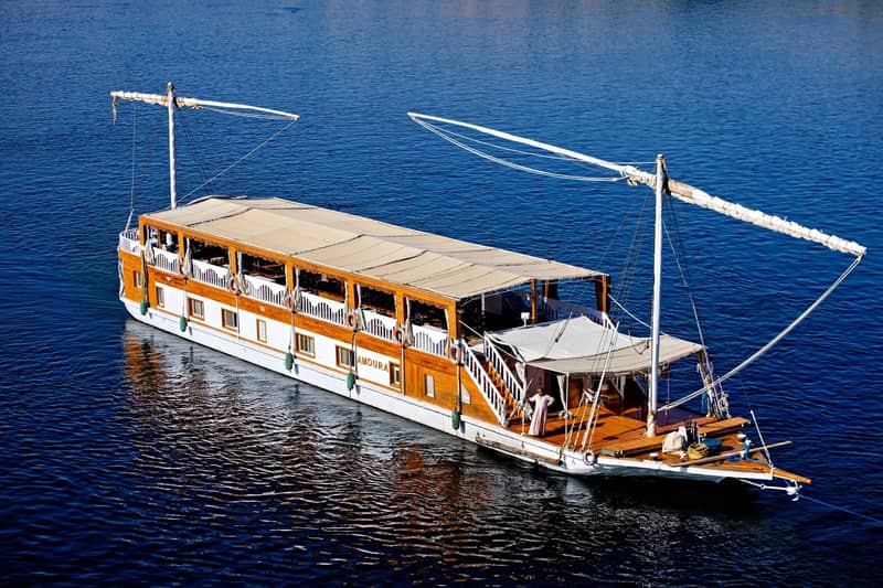 A dahabiya under sail on deep blue Nile water, seen from above