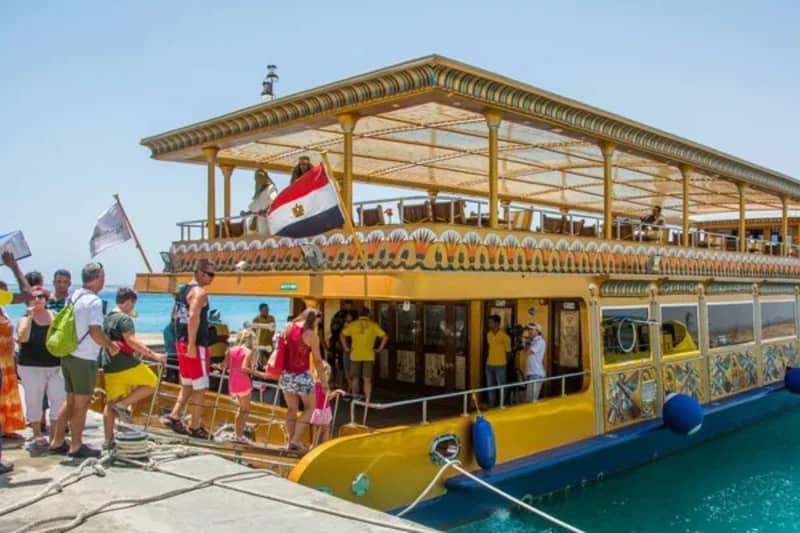 Gäste steigen am Anleger in ein gelbes Ausflugsboot