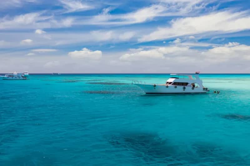 Kleines weißes Boot auf türkisfarbenem Wasser vor Hurghada
