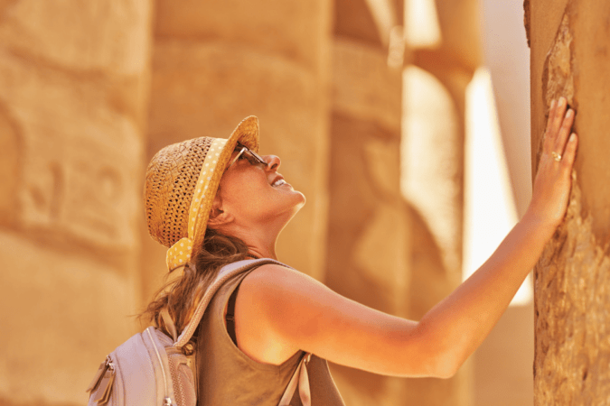 Visitor admiring ancient hieroglyphs in an Egyptian temple