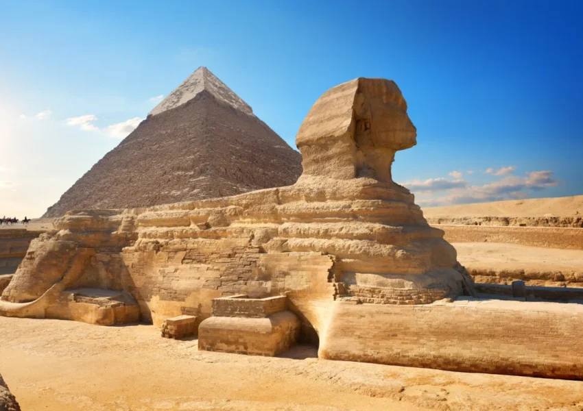 Great Sphinx and Pyramid under sunny sky.